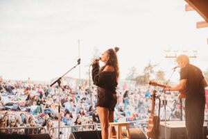 Woman on a stage singing for a large crowd